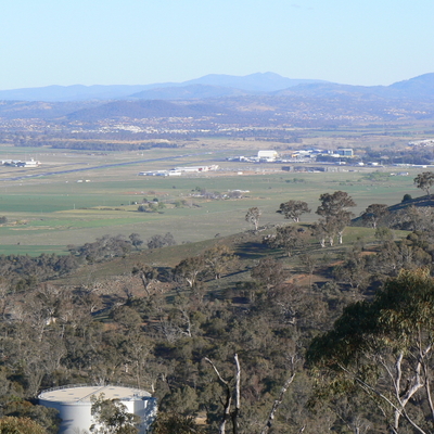 Canberra Airport in the distance, and a water reservoir on the mountain.